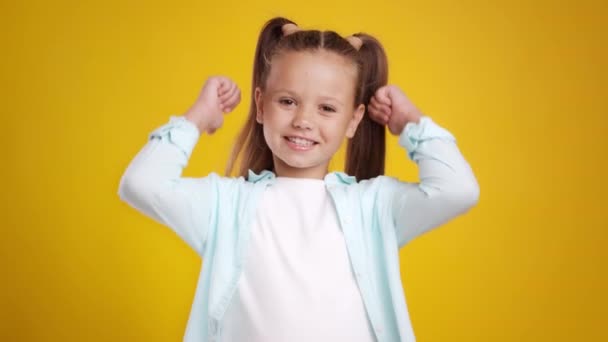 Sympathie und Zustimmung. Studioporträt eines süßen kleinen Mädchens mit zwei Pferdeschwänzen, die mit den Händen gestikulieren und lächeln — Stockvideo