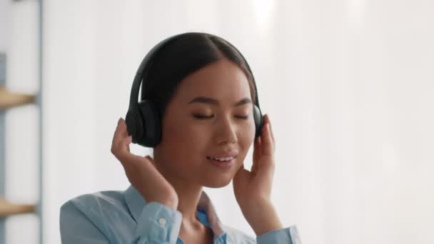 Kínai hölgy hallgat zenét viselő fejhallgató éneklés az irodában — Stock videók