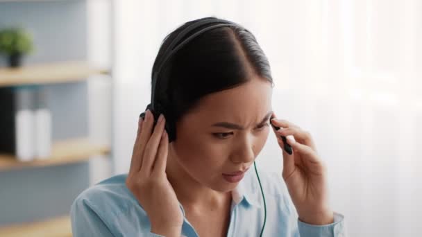 Asiatique femme d'affaires ayant un problème avec casque cassé communiquer sur le lieu de travail — Video