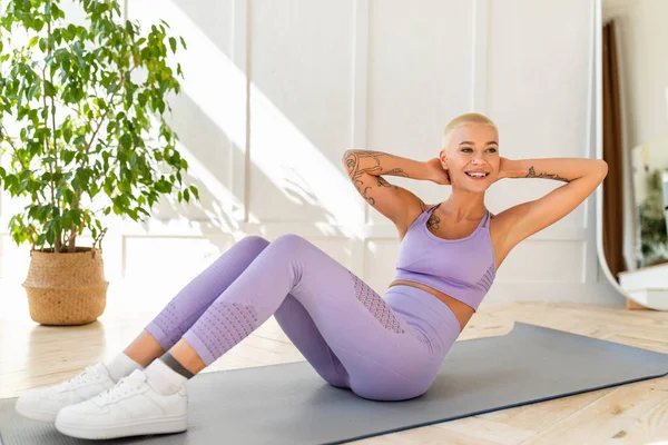 Conceito de esportes domésticos. Senhora atlética fazendo exercícios no tapete de ioga, fortalecendo seus músculos abdominais em casa — Fotografia de Stock