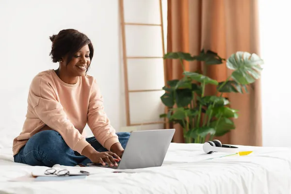 Preto freelancer senhora usando laptop trabalhando online sentado no quarto — Fotografia de Stock