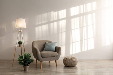 Yastıklı rahat retro koltuk, parlak lamba ve saksıda bitki, yerde sedir.