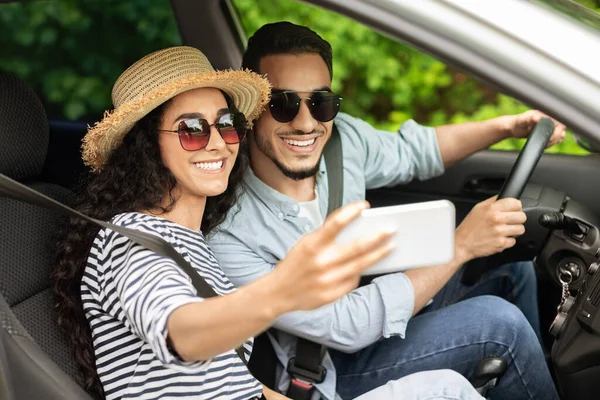 Glückliches junges Paar macht Selfie im Auto — Stockfoto