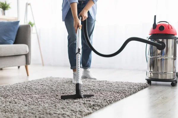 Низька секція жіночого чищення килимового килима з пилососом — стокове фото