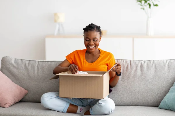 Teljes hossza pozitív fekete hölgy nyitó karton csomag, fogadó online áruház szállítás otthon — Stock Fotó