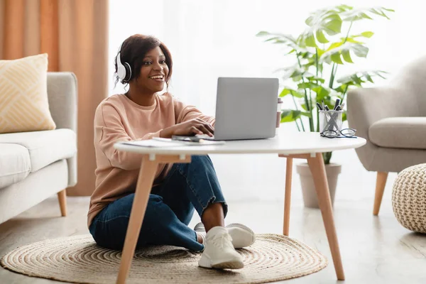 Czarna kobieta przy użyciu laptopa noszenie słuchawek Dokonywanie połączeń wideo w pomieszczeniach — Zdjęcie stockowe