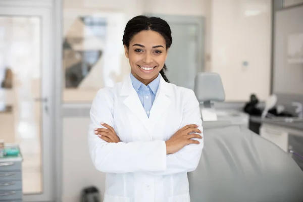 Zahnärztliche Leistungen. Porträt einer lächelnden schwarzen Zahnärztin, die in einer stomatologischen Klinik posiert — Stockfoto