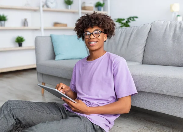 Positivo preto teen cara no casual desgaste ter on-line lição no tablet pc em casa — Fotografia de Stock