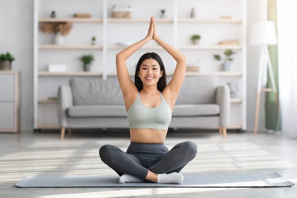 Evde Yoga. Güzel Asyalı Kadın Kafasının üstünde Eller Sıkışmış Meditasyon Yapıyor — Stok fotoğraf