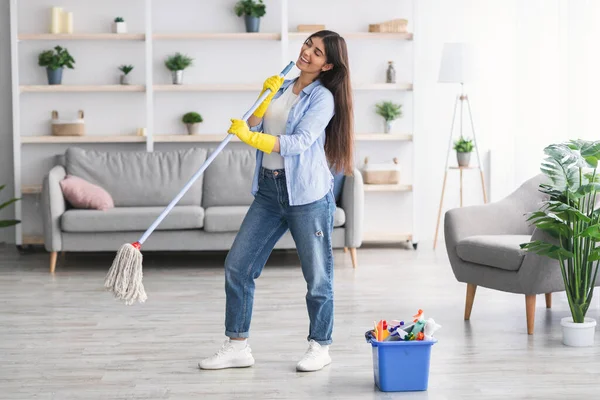 Retrato de mujer limpiando piso cantando sosteniendo fregona — Foto de Stock