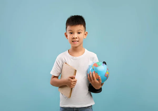 Retrato de pouco ásia menino segurando livro e mundo globo — Fotografia de Stock