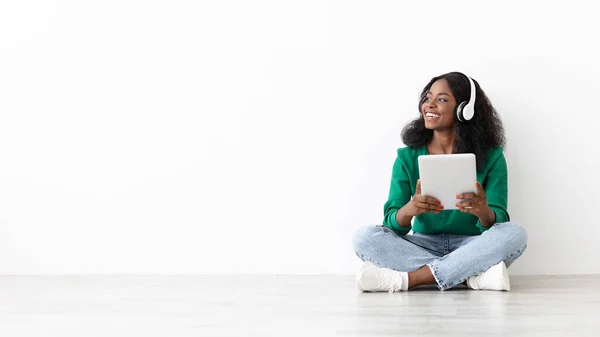 Vidám fekete nő vezeték nélküli headset és digitális tabletta — Stock Fotó
