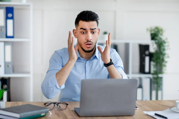 A stresszes arab üzletember laptoppal hibát követ el a munkahelyi projektben, nem tudja betartani a határidőt, rémültnek érzi magát az irodában — Stock Fotó