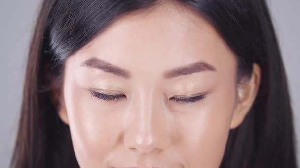 Азиатская красота. Портрет молодой красивой корейской леди, поднимающей голову и улыбающейся, смотрящей в камеру, замедленной съемки — стоковое видео