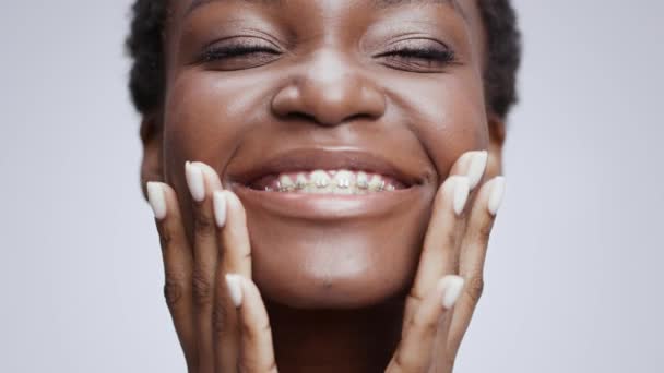 Jovem auto-confiante bela mulher afro-americana com aparelho dentário tocando seu rosto perfeito e sorrindo — Vídeo de Stock