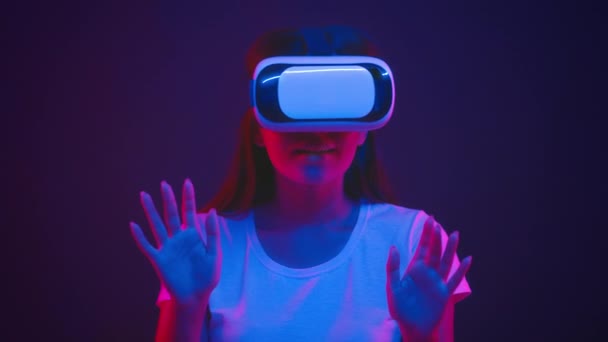 Emocionado joven mujer asiática con gafas vr jugando en línea, tocando botones virtuales en luces de neón, cámara lenta — Vídeos de Stock