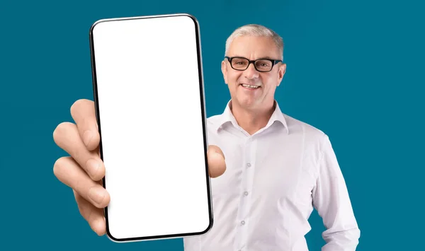 Tolle App. Lächelnder Senior zeigt Smartphone mit leerem Bildschirm vor Kamera — Stockfoto