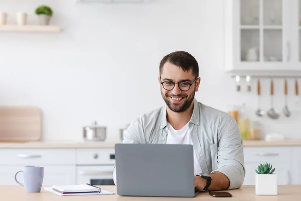 Χαμογελώντας ώριμος καυκάσιος άντρας διευθυντής ή φοιτητής με γένια σε γυαλιά εργασίας στο laptop — Φωτογραφία Αρχείου