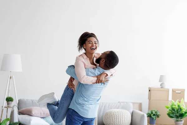 Lyckliga par flyttar till köpta hus, make lyfter upp älskad fru, familj börjar nytt liv i första bostad — Stockfoto
