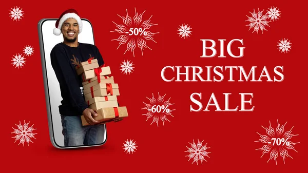 Happy black guy with xmas gifts standing in smartphone, collage — Stock Photo, Image