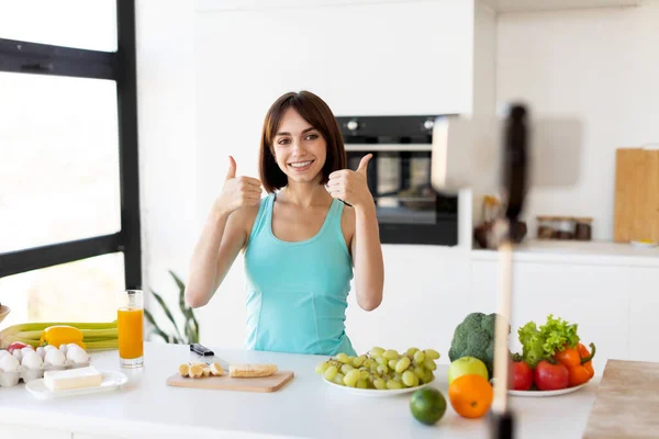 Gesunde Food-Bloggerin filmt neuen kulinarischen Videoblog, gibt Diättipps und zeigt Daumen hoch, Kücheneinrichtung — Stockfoto