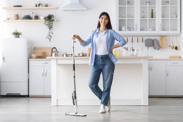 Porträtt av glad kvinna rengöring golv med spraymopp, poserar — Stockfoto