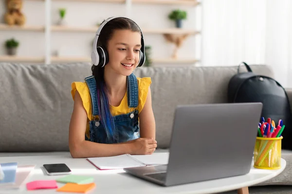 Menina usando computador pessoal, usando fone de ouvido sem fio — Fotografia de Stock