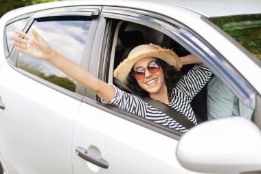 Neşeli genç bayan araba gezisine çıkarken dinleniyor.