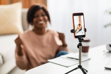 Afrikalı Amerikalı blogcu kadın evde akıllı telefondan video çekiyor