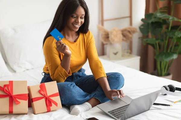 African Female Shopping Regalos con tarjeta de crédito y ordenador portátil en interiores —  Fotos de Stock
