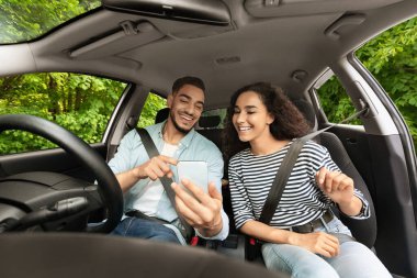 Orta doğulu bir sürücü kız arkadaşıyla seyahat ediyor, cep telefonuna GPS takıyor.