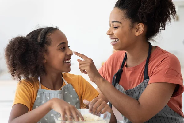 Nahaufnahme einer schwarzen Frau, die ihre Tochter mit Mehl befleckt — Stockfoto