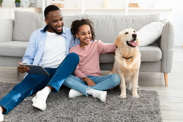 Cheerful black family spending time together with dog at home — Stock Photo, Image