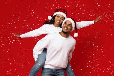 Sırtında güzel bir kız arkadaş taşıyan sevecen siyah adam.