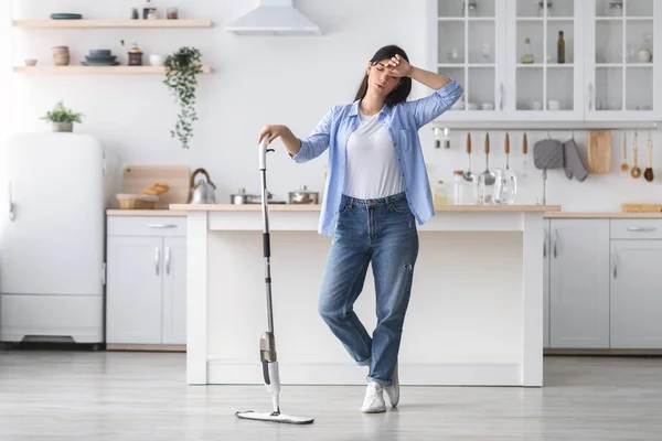 Unavená žena úklid podlahy s mop v kuchyni — Stock fotografie