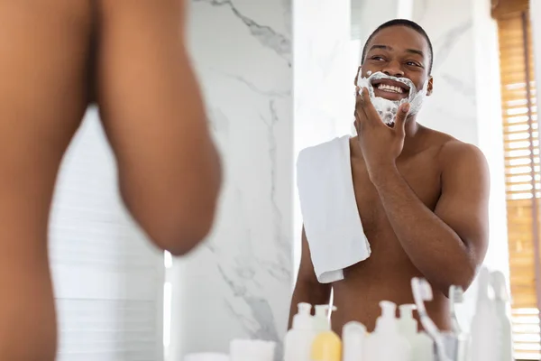 Shirtless Black Guy Blick auf Spiegel und Anwendung Rasierschaum im Badezimmer — Stockfoto