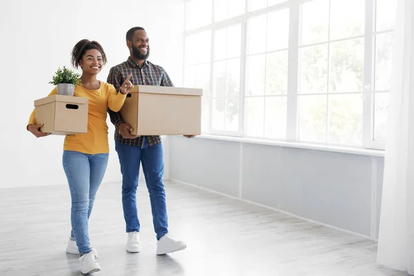 Alegre pareja afroamericana milenaria disfrutando de mudarse en nuevo apartamento, familia emocionada en el día de mudanza —  Fotos de Stock