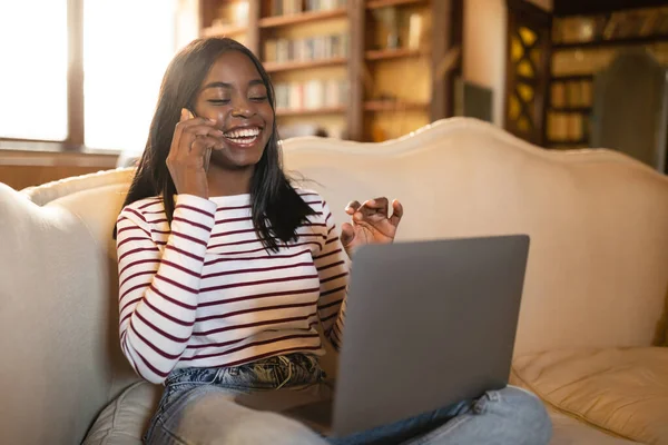Online-Arbeit, Bildungskonzept. Glückliche junge schwarze Dame telefoniert mit Laptop zu Hause — Stockfoto