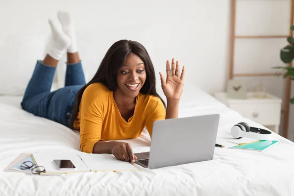 Africano donna video chiamata agitando ciao a computer portatile in camera da letto — Foto Stock