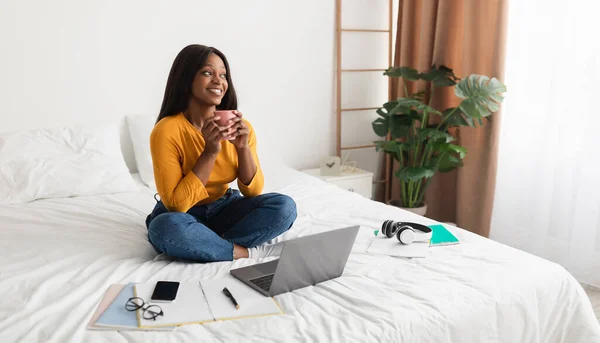 Dama afroamericana usando computadora portátil disfrutando del café en el dormitorio, Panorama — Foto de Stock