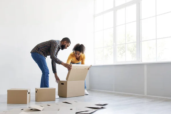 Millennial Africano americano marido ajuda esposa se preparar para se mover com caixas de papelão para as coisas — Fotografia de Stock