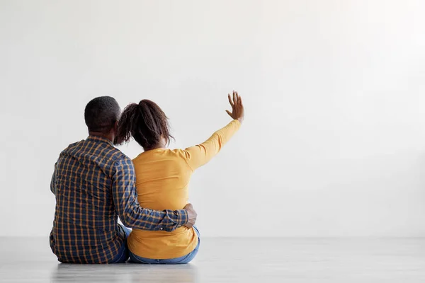 Afrykański amerykański mąż i żona siedzieć na piętrze planowania wnętrz w mieszkaniu, wybierając projekt nowego mieszkania — Zdjęcie stockowe