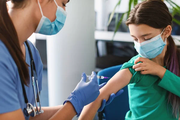 Tiener meisje ontvangen vaccinatie injectie in arm in medisch centrum — Stockfoto