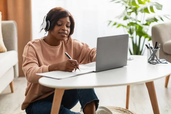 Diz üstü bilgisayarda öğrenen Afrikalı kadın evde not alıyor — Stok fotoğraf