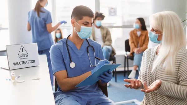 Médico hablando con una paciente madura en la cita en el hospital — Foto de Stock