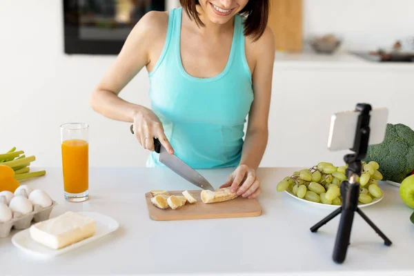 Ung bloggare förbereda fruktsallad, skära banan och spela in nya video recept för hennes mat blogg — Stockfoto