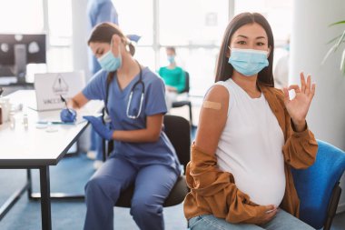 Aşılanmış Asyalı Hamile Kadın Klinikte İyi İşaret Ediyor