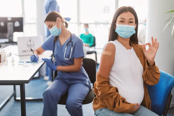 Вакцинация беременной азиатки в клинике — стоковое фото