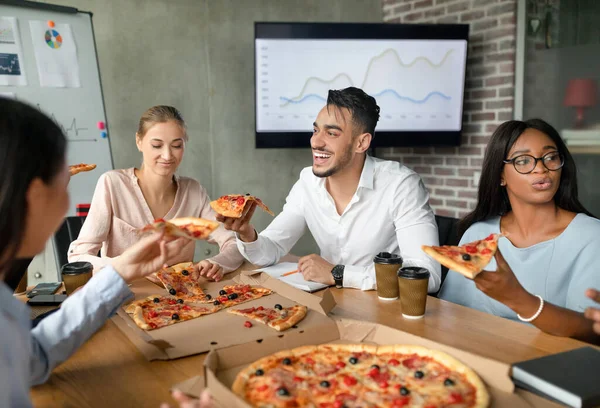 Diverse multi-etnische collega 's eten pizza tijdens de lunchpauze in het kantoor — Stockfoto