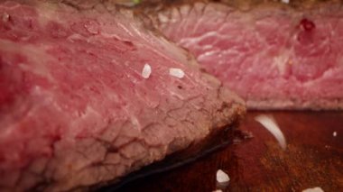 Sığır bifteğinin üzerine sert taneli tuz serpilmiş.